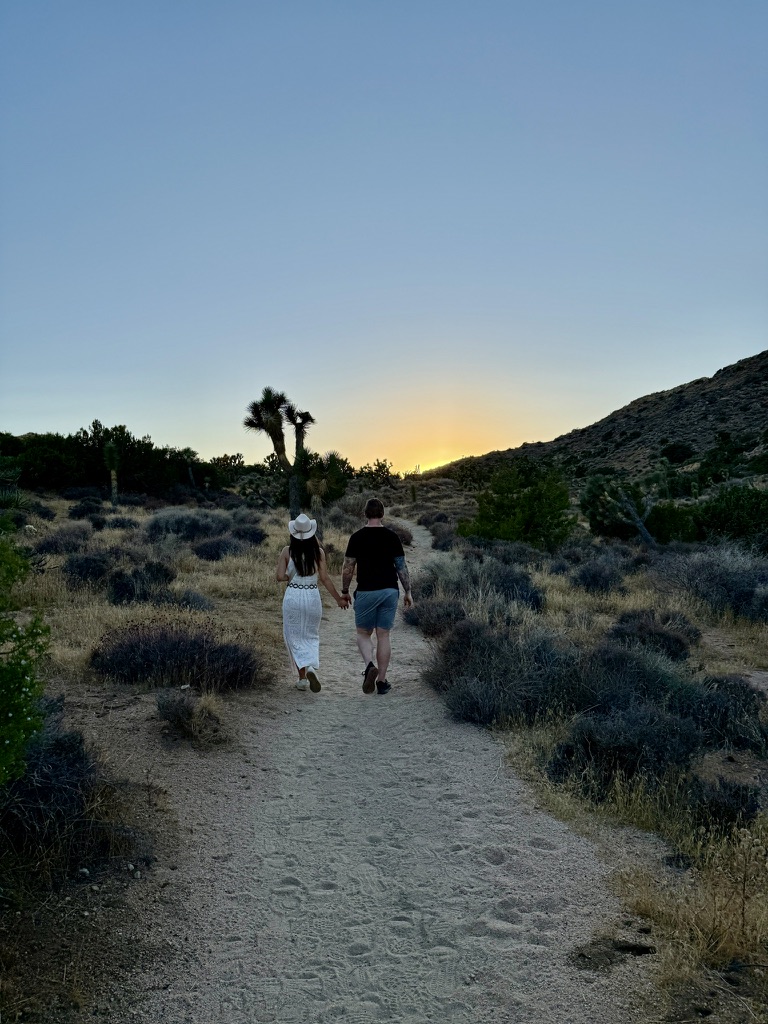 Josh and his family walking a desert trail at sunset among Joshua trees