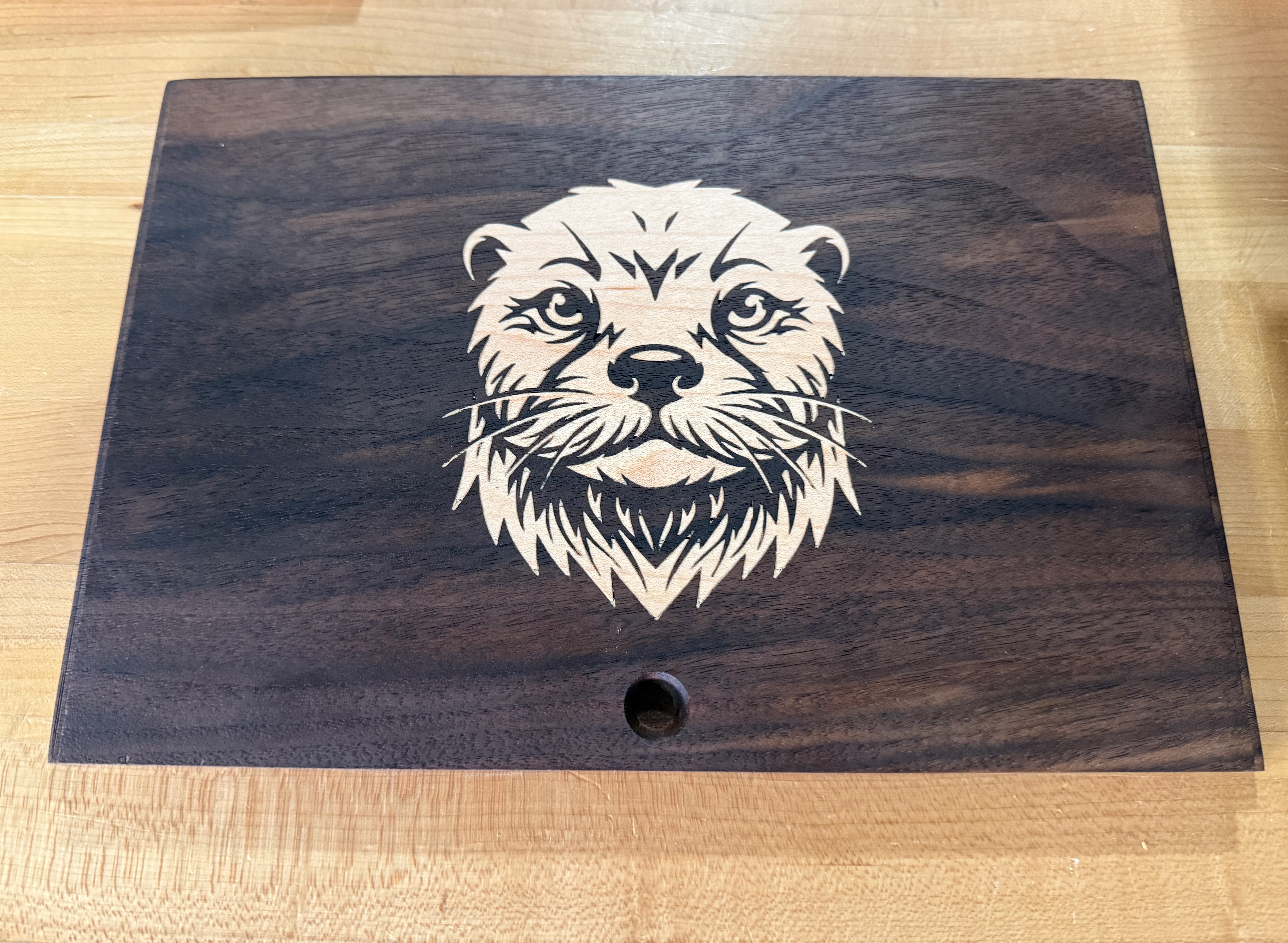 Walnut box top with a maple otter face inlay